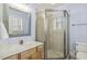 Bathroom featuring a glass shower with a tile design, a mirror, and a toilet at 4221 Bibleway Ct, Holly Springs, NC 27540