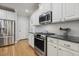 Modern kitchen with stainless steel appliances, white cabinets, and subway tile backsplash at 4221 Bibleway Ct, Holly Springs, NC 27540