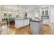 Open kitchen with black granite counters, white cabinets, stainless appliances and hardwood floors at 4221 Bibleway Ct, Holly Springs, NC 27540