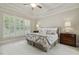 Comfortable bedroom with a tray ceiling, plush carpet, and plantation shutters for privacy at 4221 Bibleway Ct, Holly Springs, NC 27540
