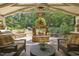 An outdoor living space featuring a stone fireplace and a view of a landscaped yard with a waterfall and pool at 4221 Bibleway Ct, Holly Springs, NC 27540