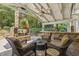 Inviting outdoor living area with a stone fireplace, comfortable seating, and a ceiling fan for comfortable entertaining at 4221 Bibleway Ct, Holly Springs, NC 27540