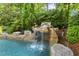 Pool with a rock waterfall offering a tranquil and refreshing outdoor experience at 4221 Bibleway Ct, Holly Springs, NC 27540