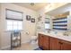 Well-lit bathroom with a double vanity, decorative mirror, and shower-tub combo at 425 Cottonseed Way, Durham, NC 27703