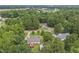 This aerial shows a home with a deck and spacious yard, nestled in lush greenery at 436 Madison Ave, Princeton, NC 27569