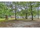 Large backyard with mature trees, playground, and deck area provides ample space for outdoor activities at 436 Madison Ave, Princeton, NC 27569