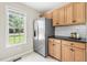 Kitchen boasts stainless steel fridge, ample storage with wood cabinets, and bright natural light at 436 Madison Ave, Princeton, NC 27569