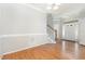 Bright entryway with gleaming hardwood floors, staircase, and a welcoming white door, creating a spacious first impression at 440 Heritage Village Ln, Apex, NC 27502