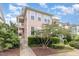 A two-story condo boasts a quaint porch and meticulous landscaping under a sunny sky, creating a welcoming atmosphere at 440 Heritage Village Ln, Apex, NC 27502