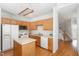 Functional kitchen layout featuring wood cabinets, white appliances, and hardwood floors, ideal for everyday cooking and entertaining at 440 Heritage Village Ln, Apex, NC 27502