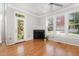 Cozy living room features hardwood floors, a fireplace, and ample natural light from large windows, creating a warm ambiance at 440 Heritage Village Ln, Apex, NC 27502