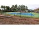 Well-maintained tennis court surrounded by trees, providing an excellent recreational amenity for residents at 440 Heritage Village Ln, Apex, NC 27502