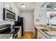 Galley kitchen with stainless steel appliances, granite counters, and modern finishes at 444 S Blount St # 209, Raleigh, NC 27601