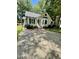 Inviting single-story house showcases a spacious driveway, mature trees, and classic design elements at 5 Sue Ann Ct, Durham, NC 27704