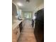 Modern kitchen features white cabinets, quartz countertops, stainless steel appliances, and updated flooring at 5 Sue Ann Ct, Durham, NC 27704
