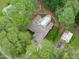 An aerial view of a home surrounded by mature trees with a backyard pool and detached garage at 502 Hillcrest Rd, Apex, NC 27502