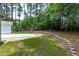 Sprawling backyard with lush lawn, retaining wall, and play set perfect for families at 502 Hillcrest Rd, Apex, NC 27502