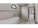Luxurious bathroom featuring travertine tile, a freestanding tub, glass shower, and decorative tiled accent border at 502 Hillcrest Rd, Apex, NC 27502