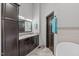 Elegant bathroom featuring double vanity with granite countertop, framed mirror, and dark wood cabinetry at 502 Hillcrest Rd, Apex, NC 27502