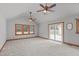 Bright bedroom featuring two ceiling fans, neutral carpet, trim, and a sliding glass door leading to an outdoor patio at 502 Hillcrest Rd, Apex, NC 27502