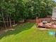 A backyard with a wooden swing set, shed, BBQ, and a slide at 504 Ashburn Ln, Durham, NC 27703