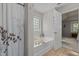 Bright bathtub featuring tile floor, bathtub caddy, and shower curtain at 504 Ashburn Ln, Durham, NC 27703