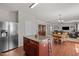 Open kitchen view with stainless steel fridge, breakfast bar, and sight lines to other living spaces at 504 Ashburn Ln, Durham, NC 27703