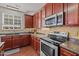 Well-appointed kitchen with stainless steel appliances, wood cabinets and tile backsplash at 504 Ashburn Ln, Durham, NC 27703