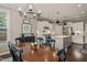 The dining room is adjacent to the kitchen with black chairs and chandelier at 508 Morning Oaks Dr, Holly Springs, NC 27540