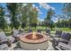 Scenic outdoor fire pit with seating surrounded by lush greenery and golf course views, perfect for relaxation at 508 Morning Oaks Dr, Holly Springs, NC 27540