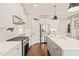Modern kitchen features white cabinets, stainless steel appliances, and a large center island with quartz countertops at 508 Morning Oaks Dr, Holly Springs, NC 27540