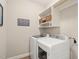 Bright laundry room with modern washer, dryer, shelving, and decor for a functional space at 508 Morning Oaks Dr, Holly Springs, NC 27540