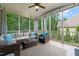 Cozy screened porch featuring wicker furniture, decorative pillows, ceiling fan, and views of backyard at 508 Morning Oaks Dr, Holly Springs, NC 27540