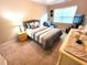 Cozy bedroom with natural light, carpeted floors, and a comfortable bed with striped comforter at 5126 Thornton Knoll Way, Raleigh, NC 27616