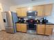 Bright kitchen features stainless steel appliances, granite countertops, and oak colored cabinets at 5126 Thornton Knoll Way, Raleigh, NC 27616