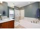 Well-lit bathroom with a glass-enclosed shower and tub, along with double sinks and chrome fixtures at 513 Dragby Ln, Raleigh, NC 27603