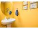 Stylish powder room featuring a pedestal sink and bright yellow walls at 513 Dragby Ln, Raleigh, NC 27603