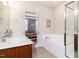 Bright bathroom with a soaking tub, tiled floor, and an open doorway to the living area at 513 Dragby Ln, Raleigh, NC 27603