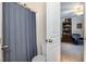 Bright bathroom with a blue shower curtain and view to a cozy sitting room at 513 Dragby Ln, Raleigh, NC 27603
