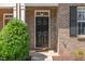 Front door of red brick home with well-manicured landscaping at 513 Dragby Ln, Raleigh, NC 27603
