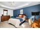 Comfortable main bedroom with blue accent wall, tray ceiling and comfortable furnishings at 513 Dragby Ln, Raleigh, NC 27603