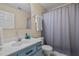 Bathroom with blue vanity, white sink, toilet, and shower with a curtain at 5801 Hadrian Dr, Durham, NC 27703
