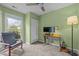 Bedroom with green walls, carpeted flooring, a ceiling fan, and a view to the front yard at 5801 Hadrian Dr, Durham, NC 27703