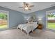 Comfortable bedroom features a ceiling fan, carpet, and two windows offering natural light at 5801 Hadrian Dr, Durham, NC 27703