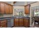 Functional kitchen with stainless steel appliances, dark countertops, wood cabinets and a serving hatch overlooking the living room at 5801 Hadrian Dr, Durham, NC 27703
