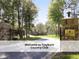 Stone entrance sign to Treyburn Country Club with manicured landscaping and tree lined drive at 603 Red Cedar Cir, Durham, NC 27712