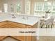 Clean kitchen with white countertops, breakfast bar, stainless faucet, and seating area by sunlit windows at 603 Red Cedar Cir, Durham, NC 27712