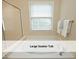 An elegant soaker tub sits beneath a window, creating a serene bathing experience at 603 Red Cedar Cir, Durham, NC 27712
