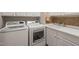 Bright laundry room featuring white cabinetry, sink, and modern appliances at 610 Mixboro Dr, Cary, NC 27519