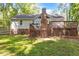 Wide shot of the backyard featuring a two level wooden deck, brick foundation and well manicured lawn at 6129 Krandon Dr, Raleigh, NC 27603